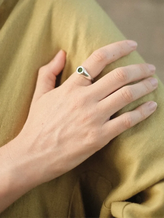 Detal pierścionka z ciemnym kamieniem – srebrny sygnet z nefrytem.