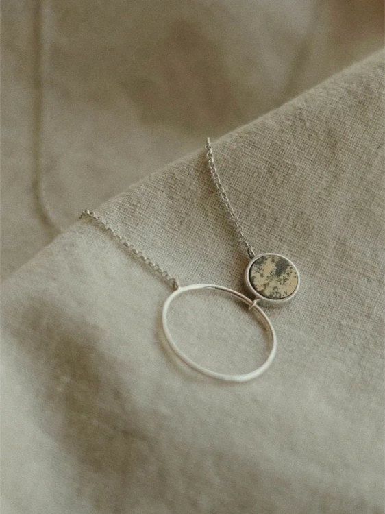 Detal srebrnego naszyjnika z okręgiem i krajobrazowym kamieniem – polska biżuteria artystyczna Kamena.