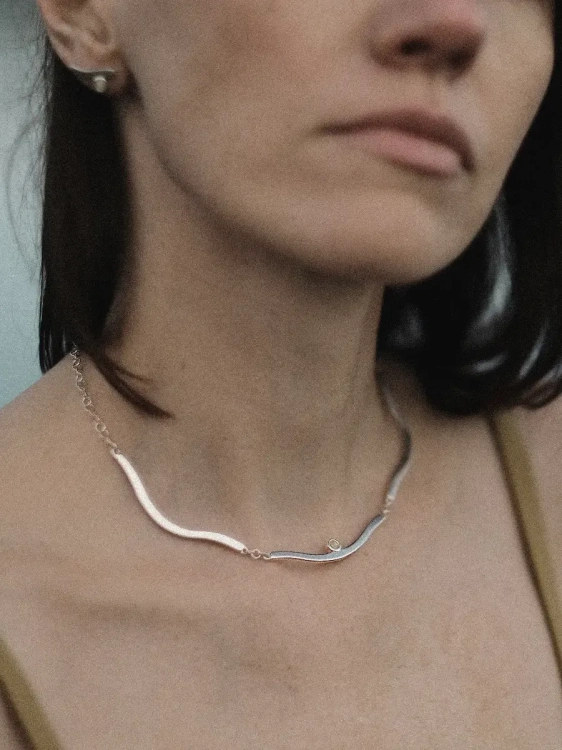 Srebrny opływowy choker z oczkiem z mlecznego bursztynu.