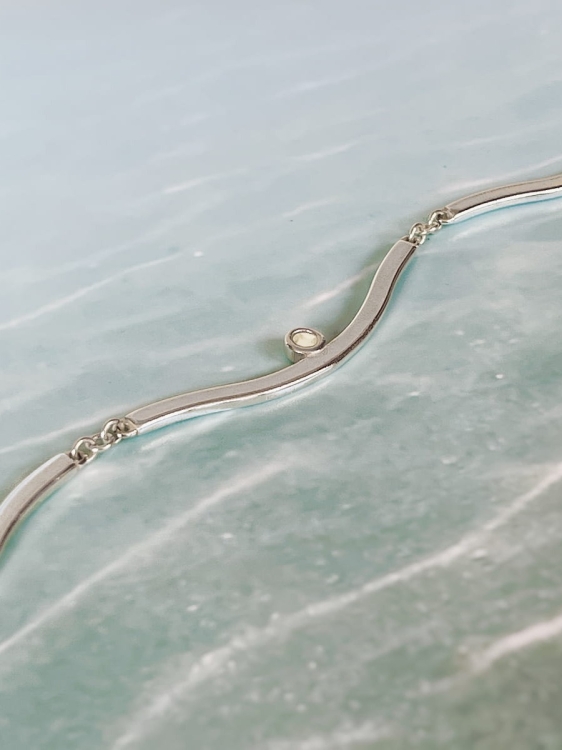 Kolia ze srebra w kształcie fali z białym bursztynem.