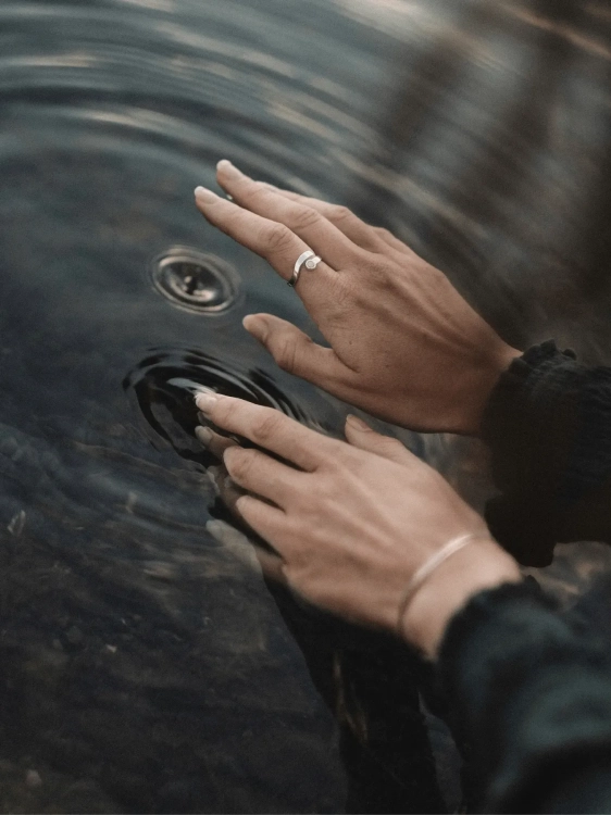 Srebrny pierścionek z mlecznym bursztynem na dłoni