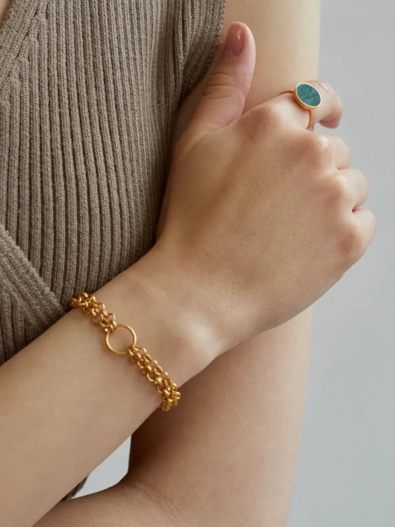 Złoty pierścionek z dużym zielonym kamieniem naturalnym na dłoni