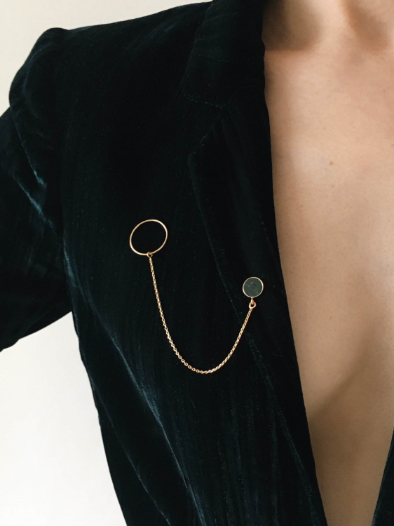 Złota broszka z zielonym kamieniem nefrytem i delikatnym łańcuszkiem - symbol szyku.