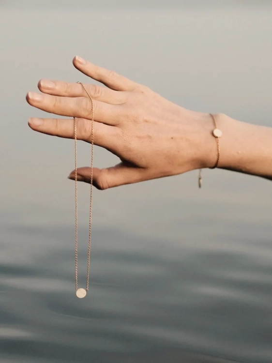 Pozłacany naszyjnik z białym opalem na szyi