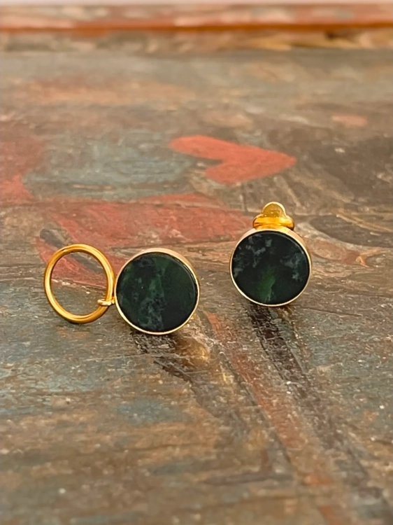 Kolczyki bez przekłuwania - zbliżenie na klipsy z nefrytem na tle rustykalnego blatu .