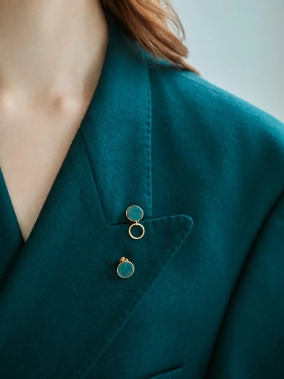 Złote kolczyki klipsy z zielonymi kamieniami i kółkiem.