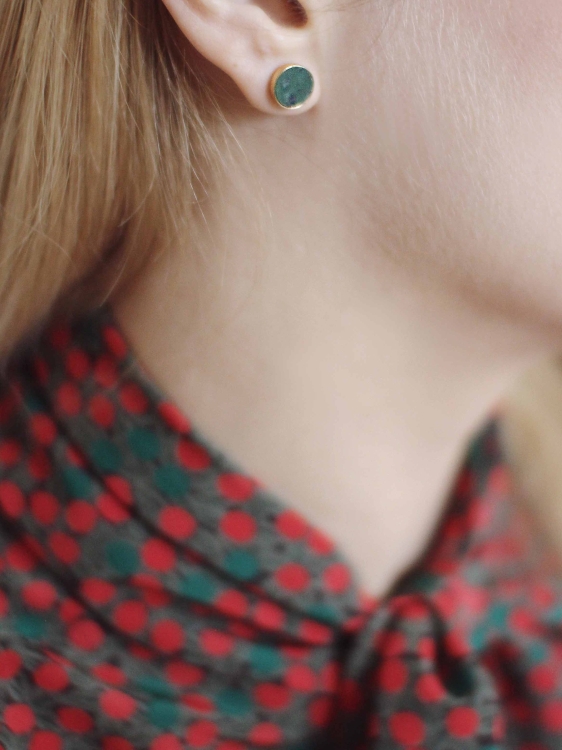Złocone srebrne kolczyki sztyfty z nefrytem noszone na modelce - subtelny dodatek do każdej stylizacji.